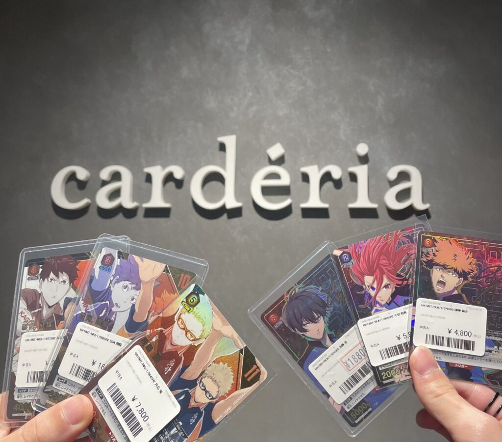 cardériaの壁面ロゴとカードを手に持った店舗内での写真